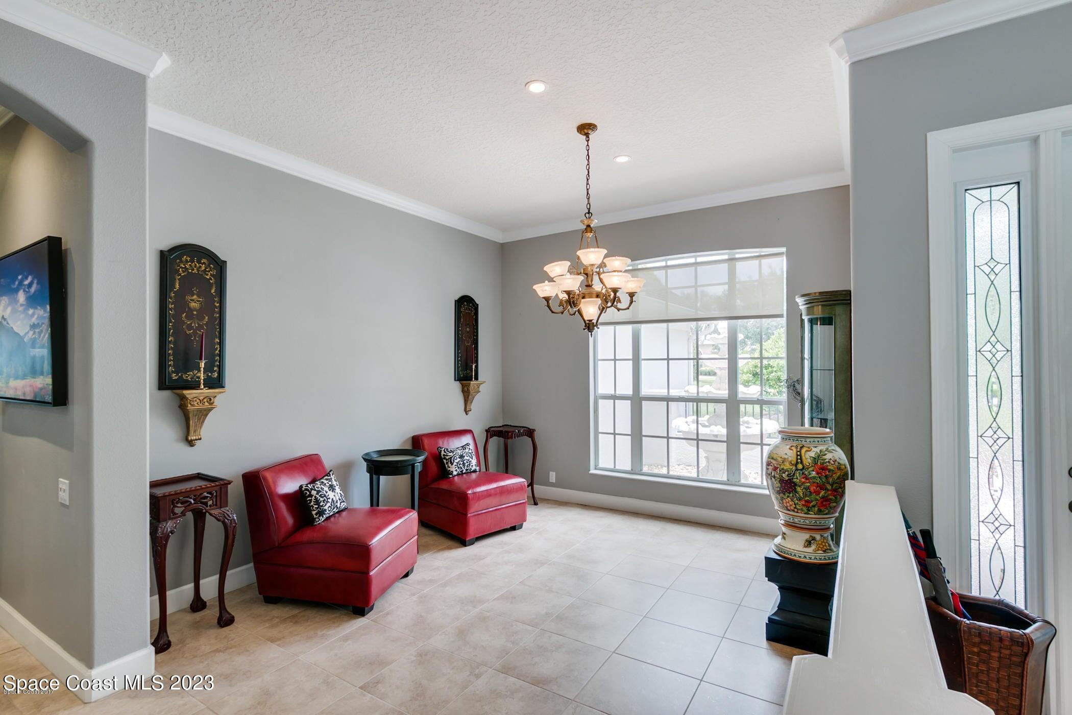 1840 Winding Ridge Circle Southeast Palm Bay, FL 32909 - Photo 12 of 41 a living room with furniture and a chandelier