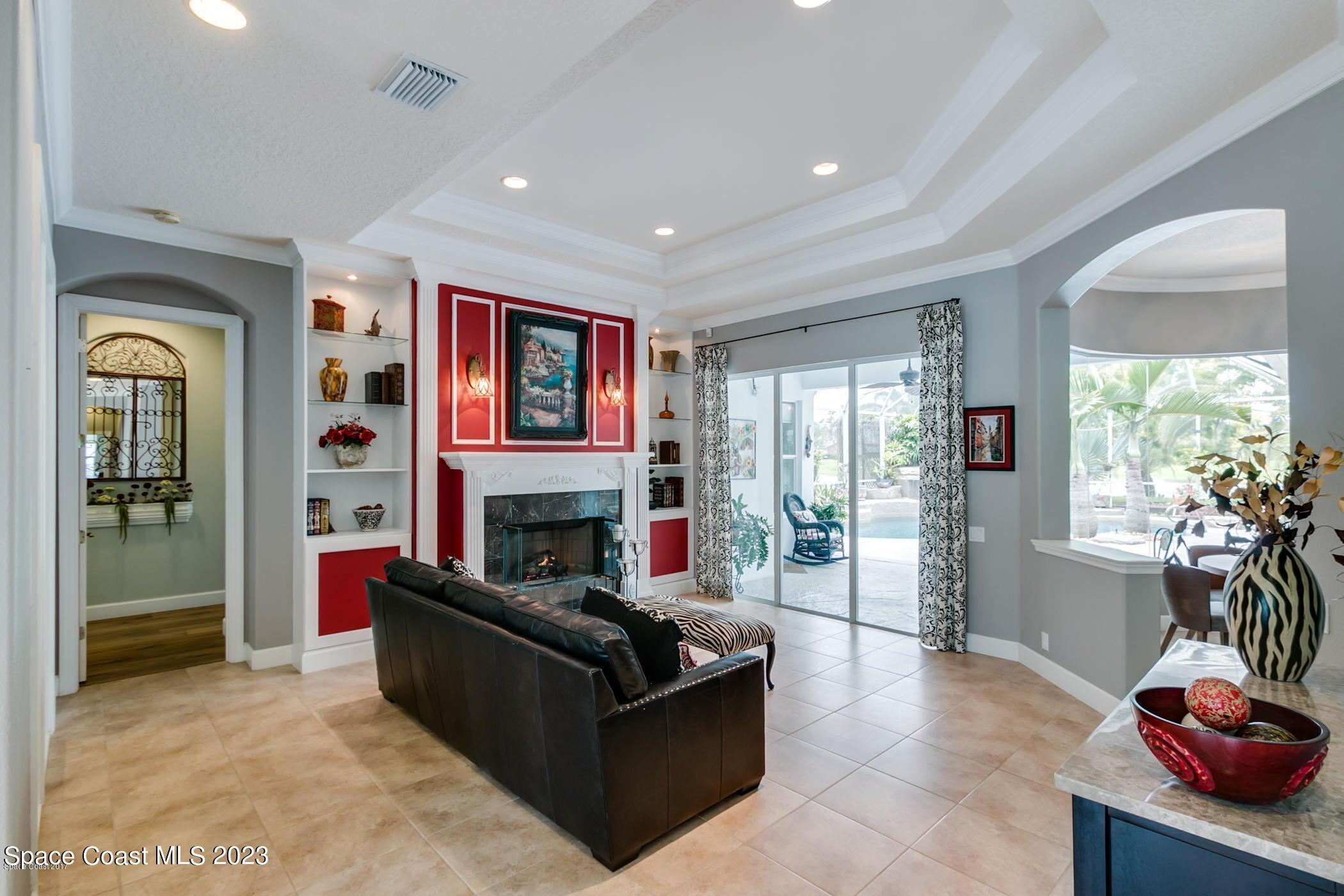 1840 Winding Ridge Circle Southeast Palm Bay, FL 32909 - Photo 13 of 41 a living room with furniture large window and a fireplace