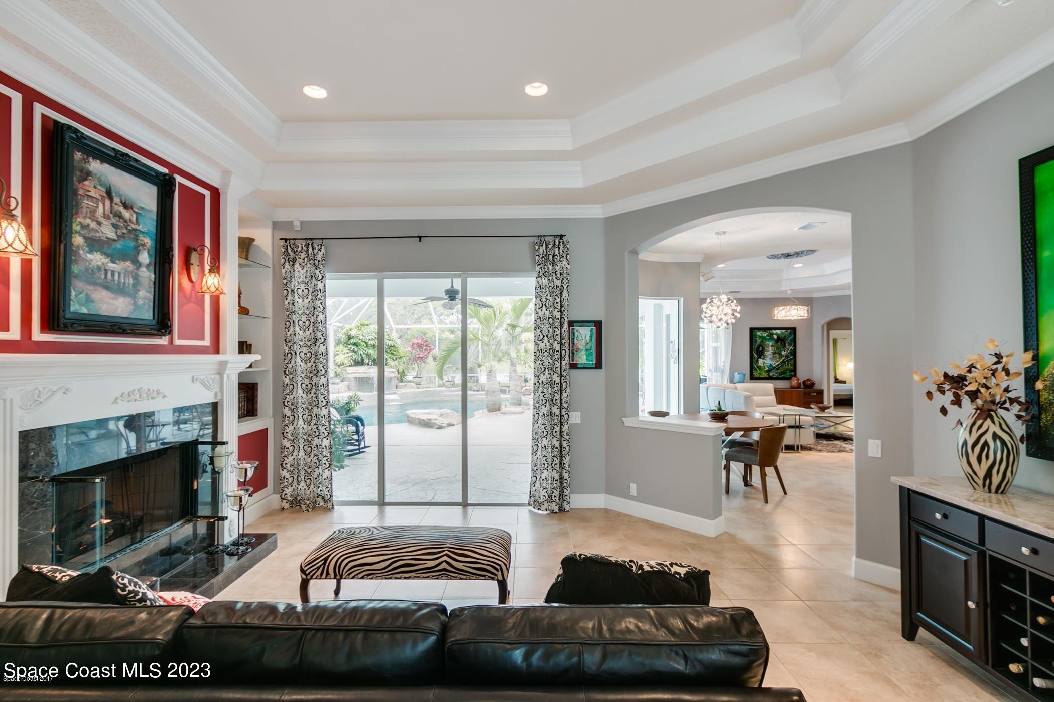 1840 Winding Ridge Circle Southeast Palm Bay, FL 32909 - Photo 14 of 41 a living room with furniture large window and a fireplace