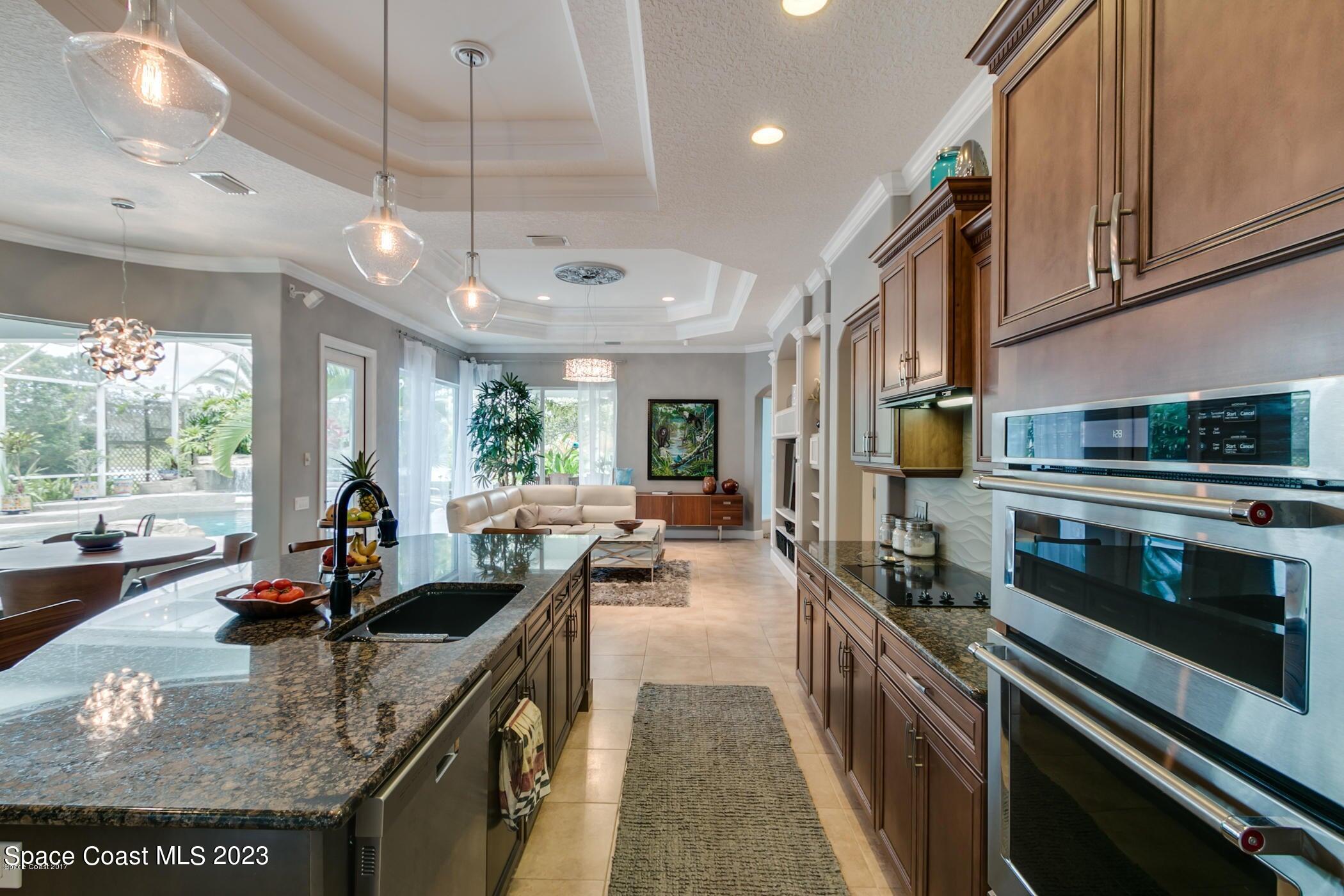 1840 Winding Ridge Circle Southeast Palm Bay, FL 32909 - Photo 18 of 41 a kitchen with stainless steel appliances granite countertop a sink counter space cabinets a stove and a window