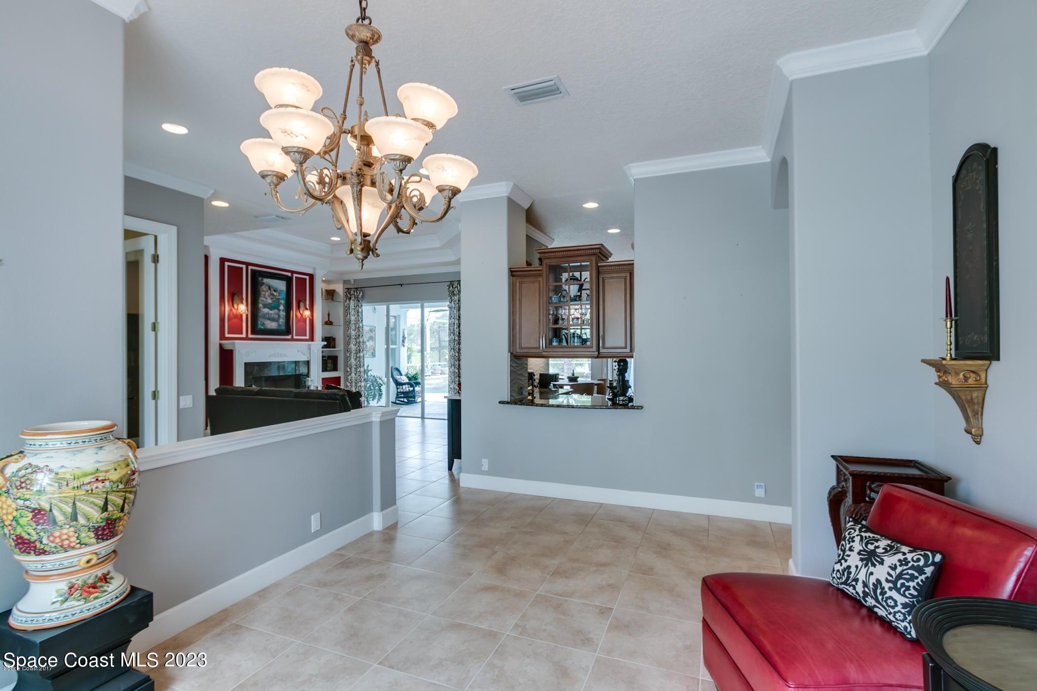 1840 Winding Ridge Circle Southeast Palm Bay, FL 32909 - Photo 23 of 41 a living room with furniture flowerpot and a chandelier