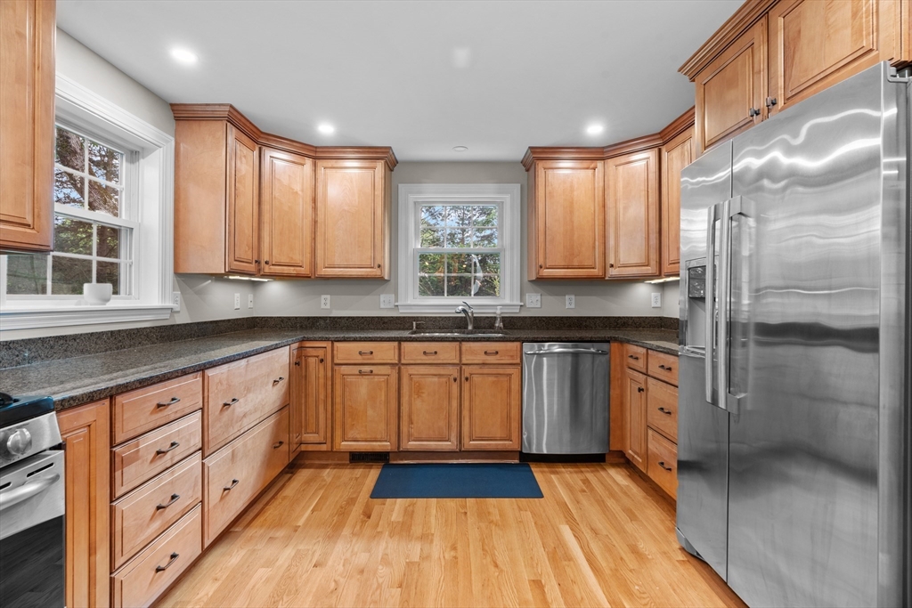 26 Cushing Road Westwood, MA 02090 - Photo 11 of 42 a kitchen with stainless steel appliances granite countertop a stove a sink and a refrigerator