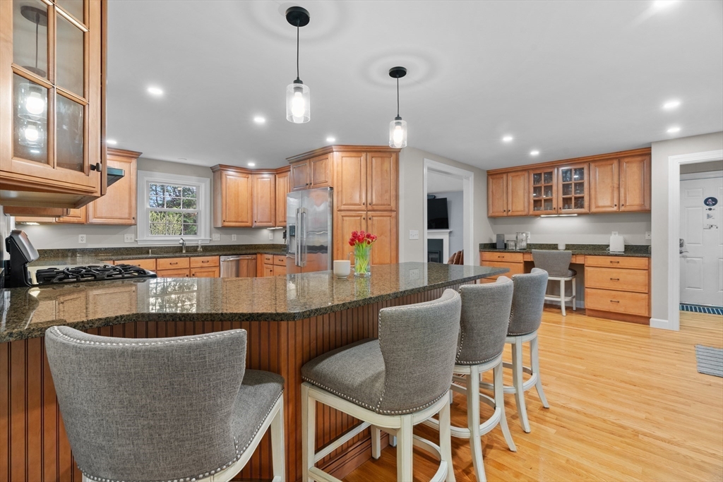 26 Cushing Road Westwood, MA 02090 - Photo 10 of 42 a kitchen with stainless steel appliances granite countertop a stove a sink a refrigerator dining table and chairs