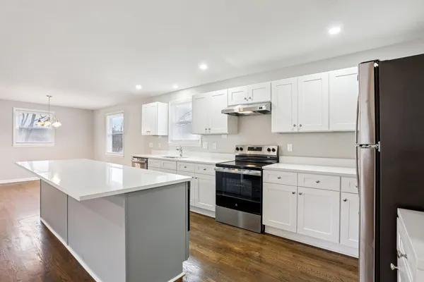 a kitchen with white cabinets appliances and sink