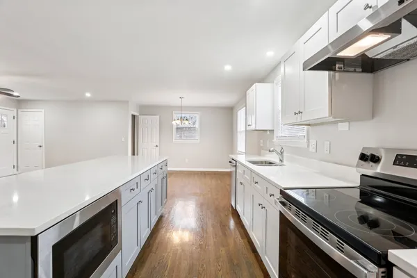 a kitchen with a sink stove and cabinets