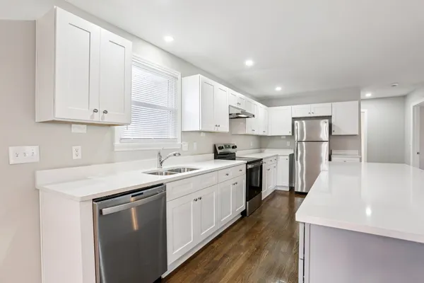 a kitchen with white cabinets sink and white appliances