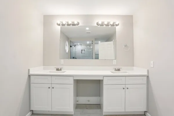 a bathroom with a double vanity sink mirror and