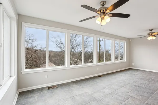 an empty room with a window and a fan
