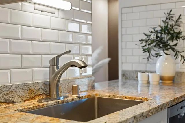 a kitchen with a sink and a granite counter top