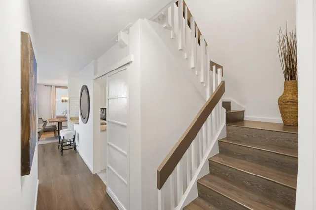 a view of a hallway with wooden floor and staircase