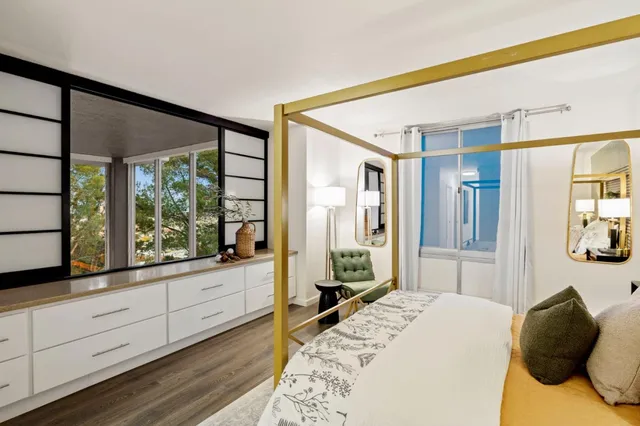 a bedroom with a bed and large windows