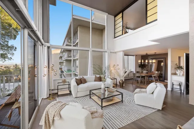 a living room with furniture a large window and wooden floor