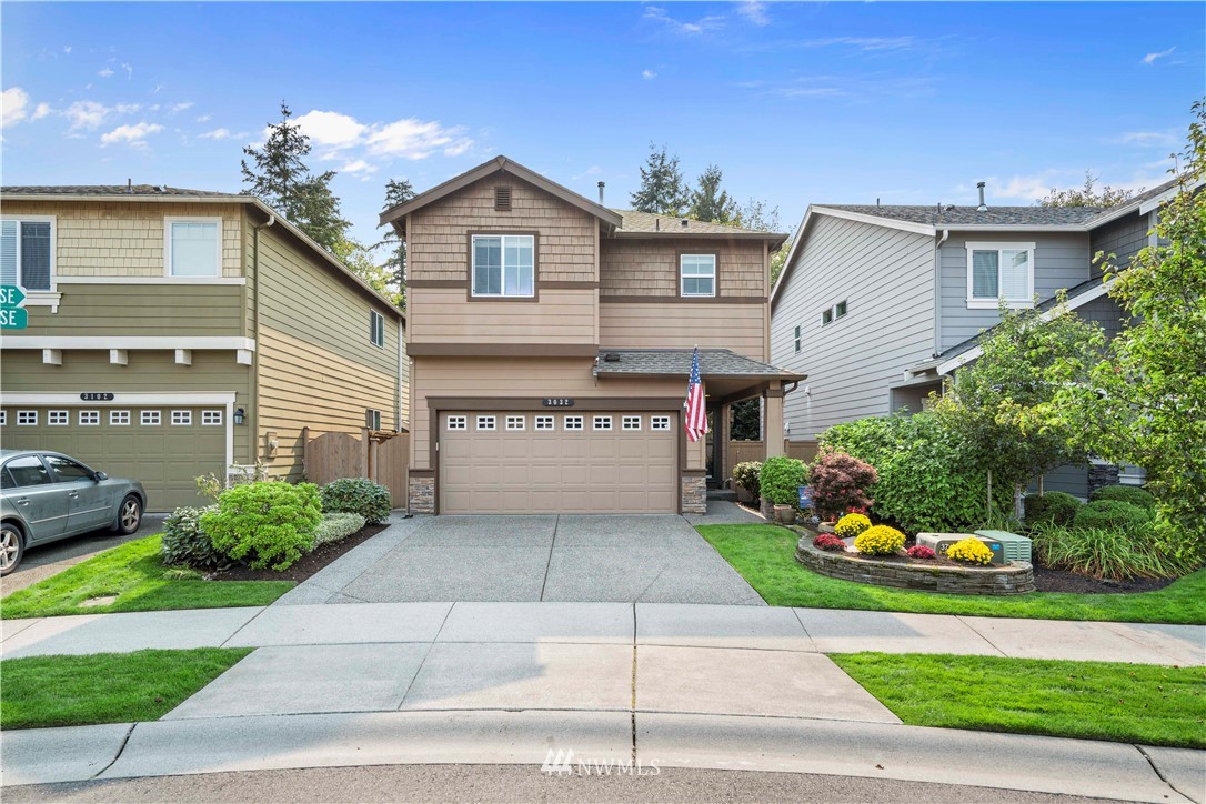 a front view of a house with a yard and potted plants