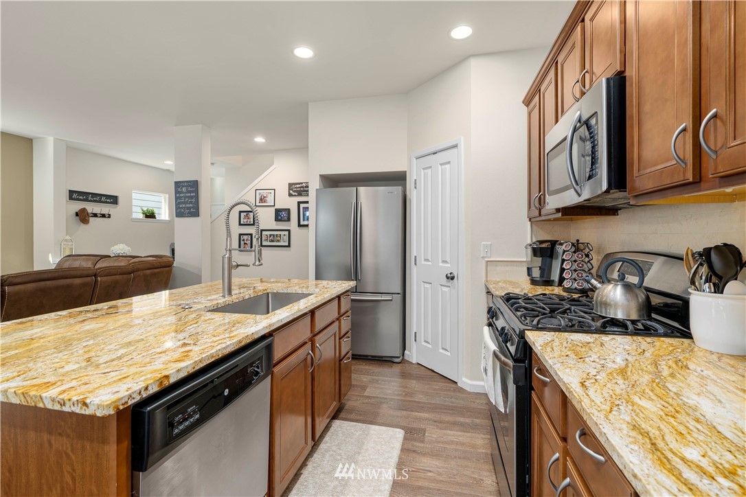 3032 183rd Place Southeast Bothell, WA 98012 - Photo 5 of 21 a kitchen with granite countertop kitchen island stainless steel appliances a sink stove and refrigerator