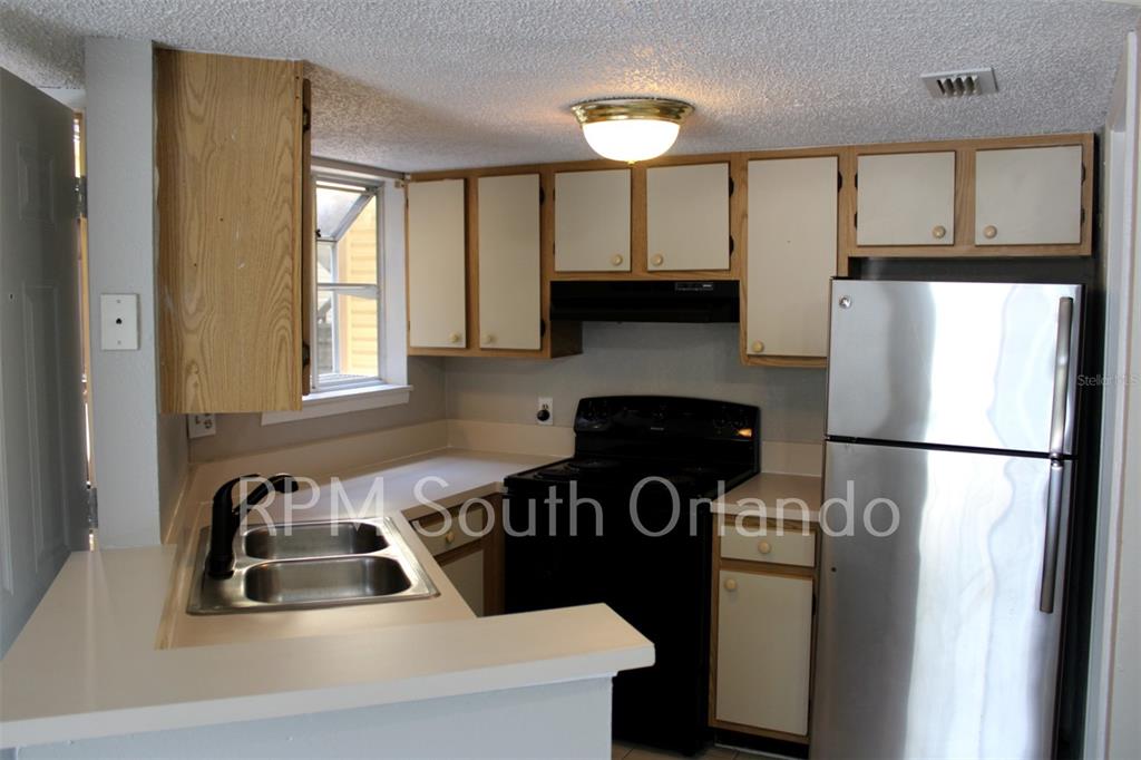 1908 Lake Atriums Circle, Unit 6 Orlando, FL 32839 - Photo 2 of 10 a kitchen with a refrigerator and a sink