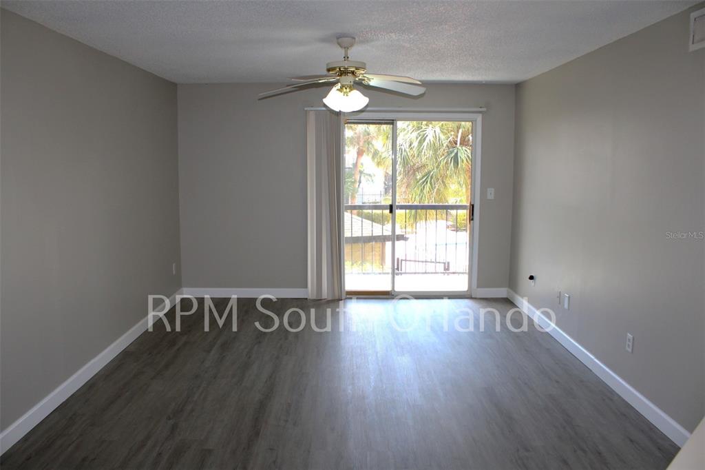 1908 Lake Atriums Circle, Unit 6 Orlando, FL 32839 - Photo 3 of 10 a view of an empty room with wooden floor and a window