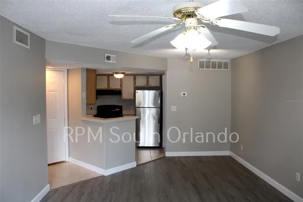 a view of a kitchen with a fridge and wooden floor