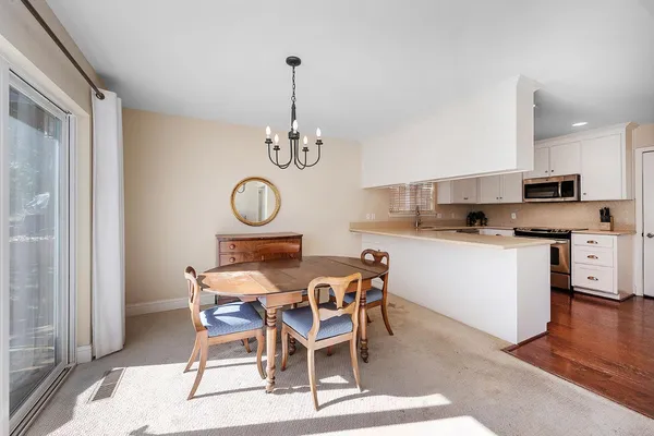 a dining room with furniture a chandelier and a rug