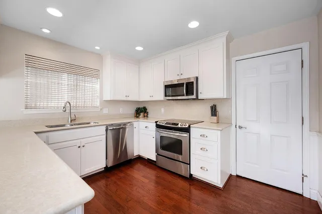 a kitchen with granite countertop cabinets stainless steel appliances and wooden floor