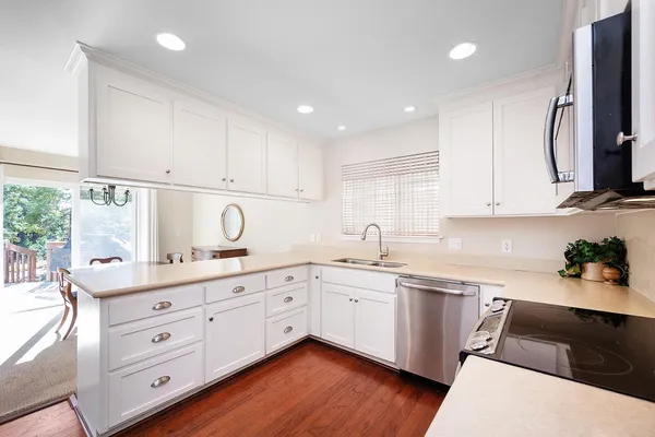 a kitchen with granite countertop a sink cabinets and stainless steel appliances