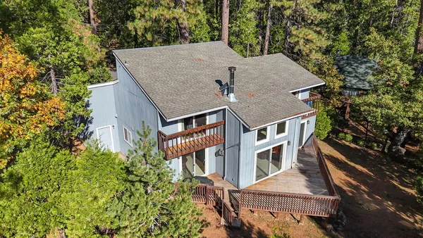 an aerial view of a house with a yard and balcony
