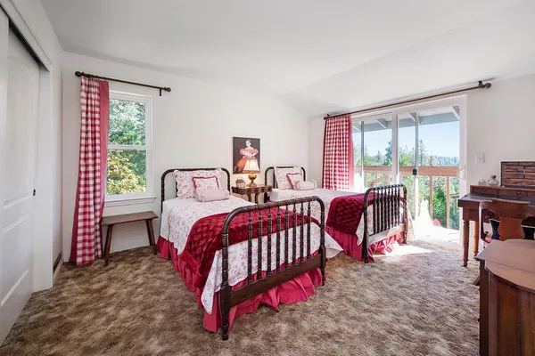 a bedroom with two beds and a two windows