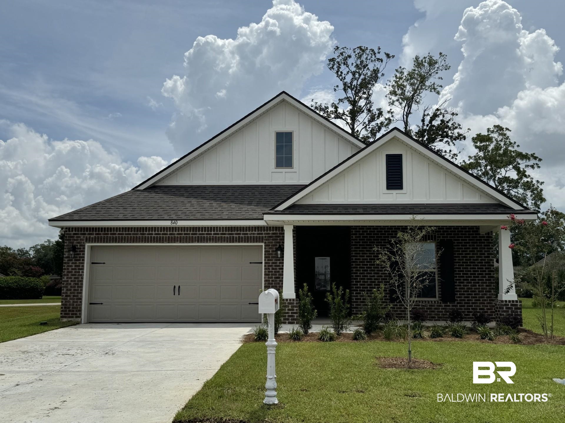 View of front facade featuring a garage and a front lawn