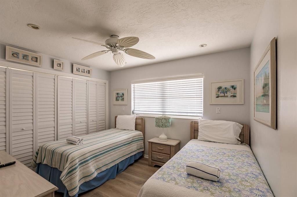 6020 Midnight Pass Road, Unit 59 Sarasota, FL 34242 - Photo 8 of 12 a bedroom with a bed and a chandelier