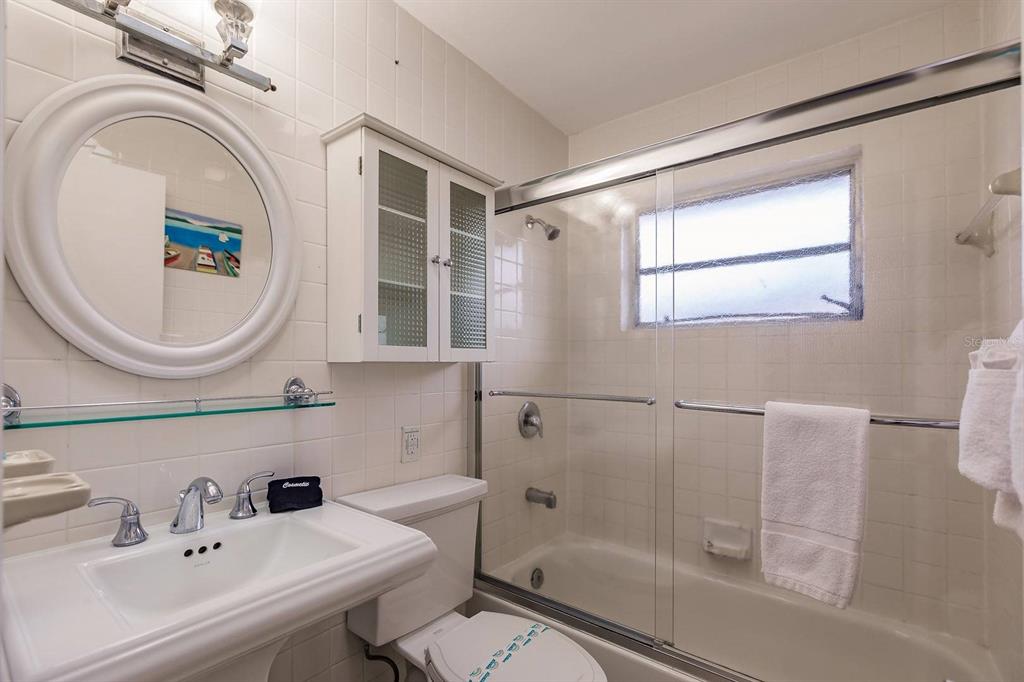 6020 Midnight Pass Road, Unit 59 Sarasota, FL 34242 - Photo 10 of 12 a bathroom with a sink a mirror a toilet and a shower