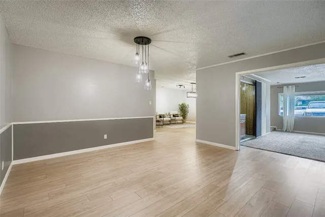 a view of a livingroom with wooden floor and a ceiling fan