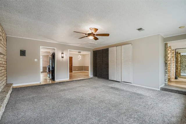 an empty room with closet and a ceiling fan