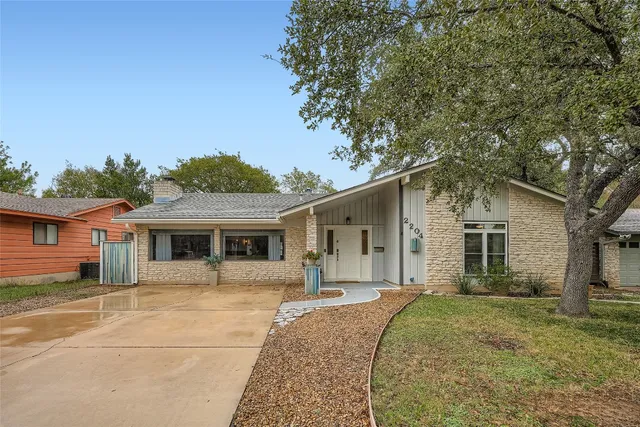 a front view of house with yard and trees in the background