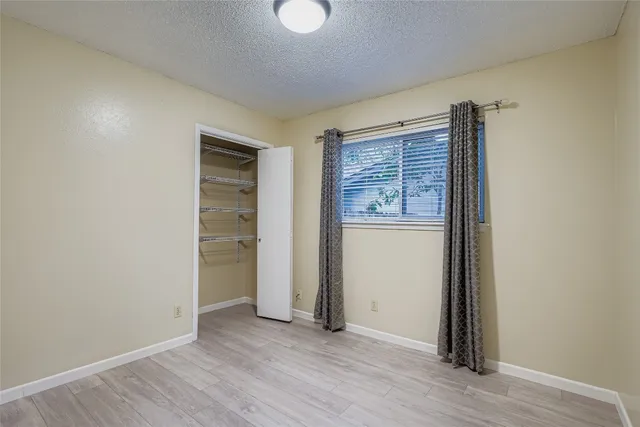 an empty room with wooden floor cabinet and closet