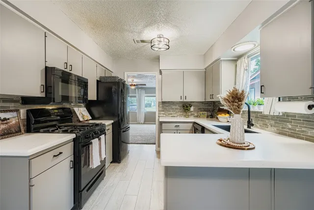 a kitchen with kitchen island granite countertop a sink appliances and cabinets