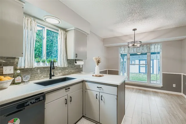 a kitchen with a sink and large windows