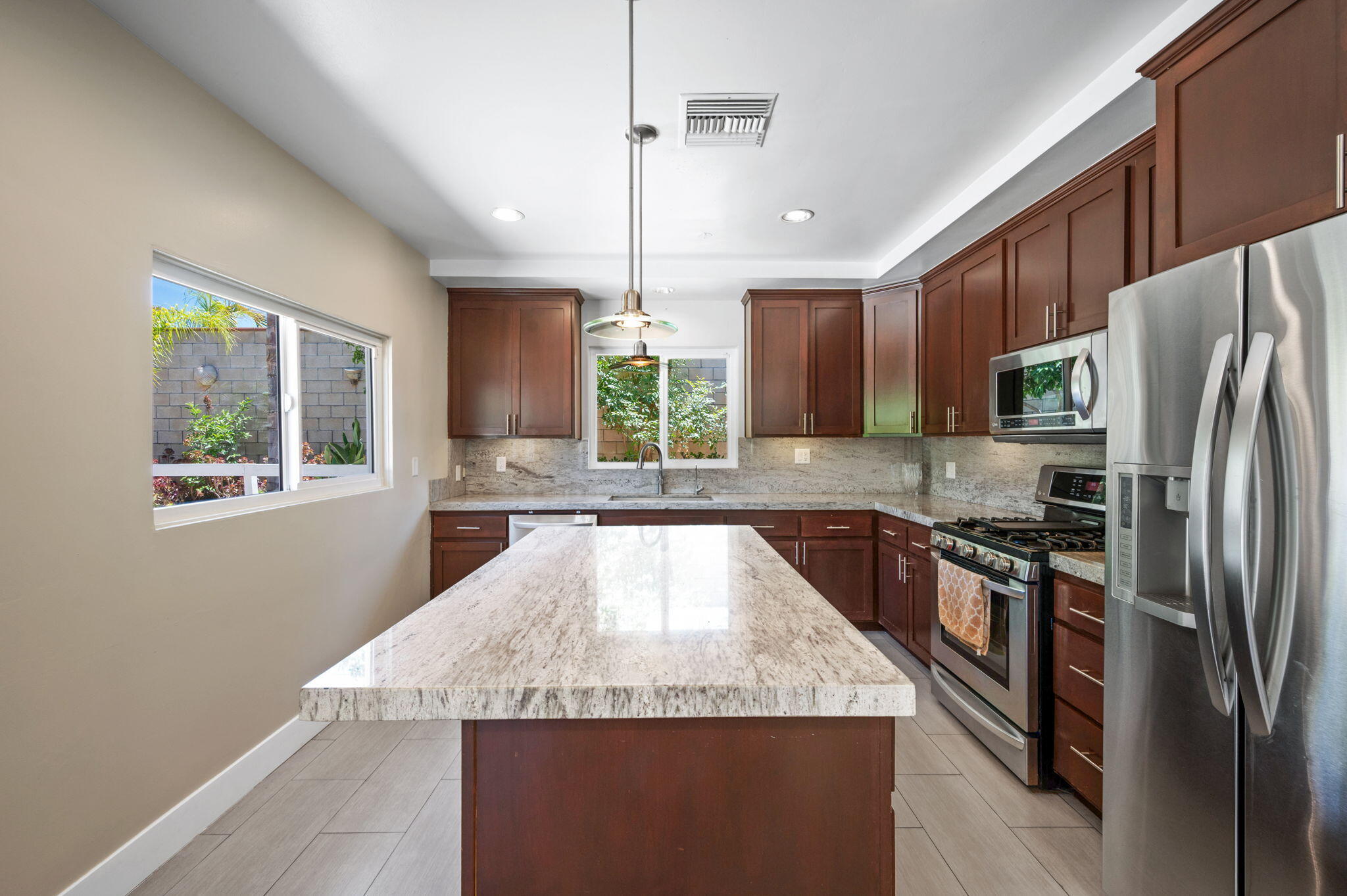 5905 Old Wheeler Road La Verne, CA 91750 - Photo 19 of 81 a large kitchen with stainless steel appliances granite countertop a refrigerator a sink dishwasher a stove a dining table and chairs with wooden floor
