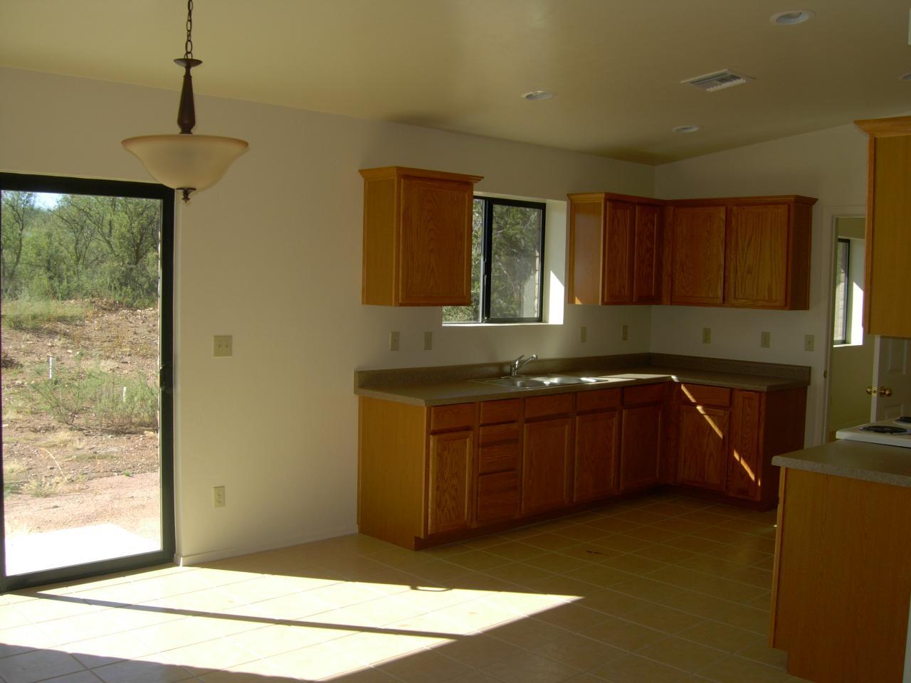 175 Tim Court Rio Rico, AZ 85648 - Photo 4 of 5 a kitchen with granite countertop a stove a sink and a granite counter top