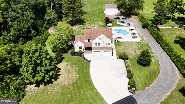 an aerial view of residential houses with outdoor space and trees