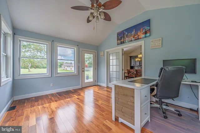 a view of a workspace with furniture and a window