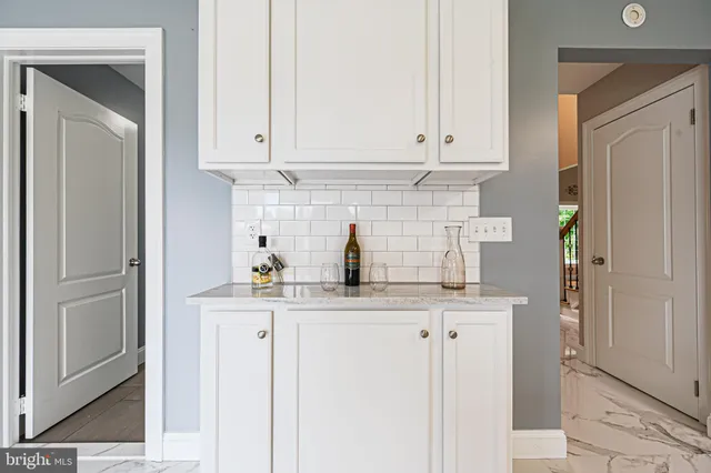 a kitchen with stainless steel appliances granite countertop a stove top oven a sink a dining table and chairs