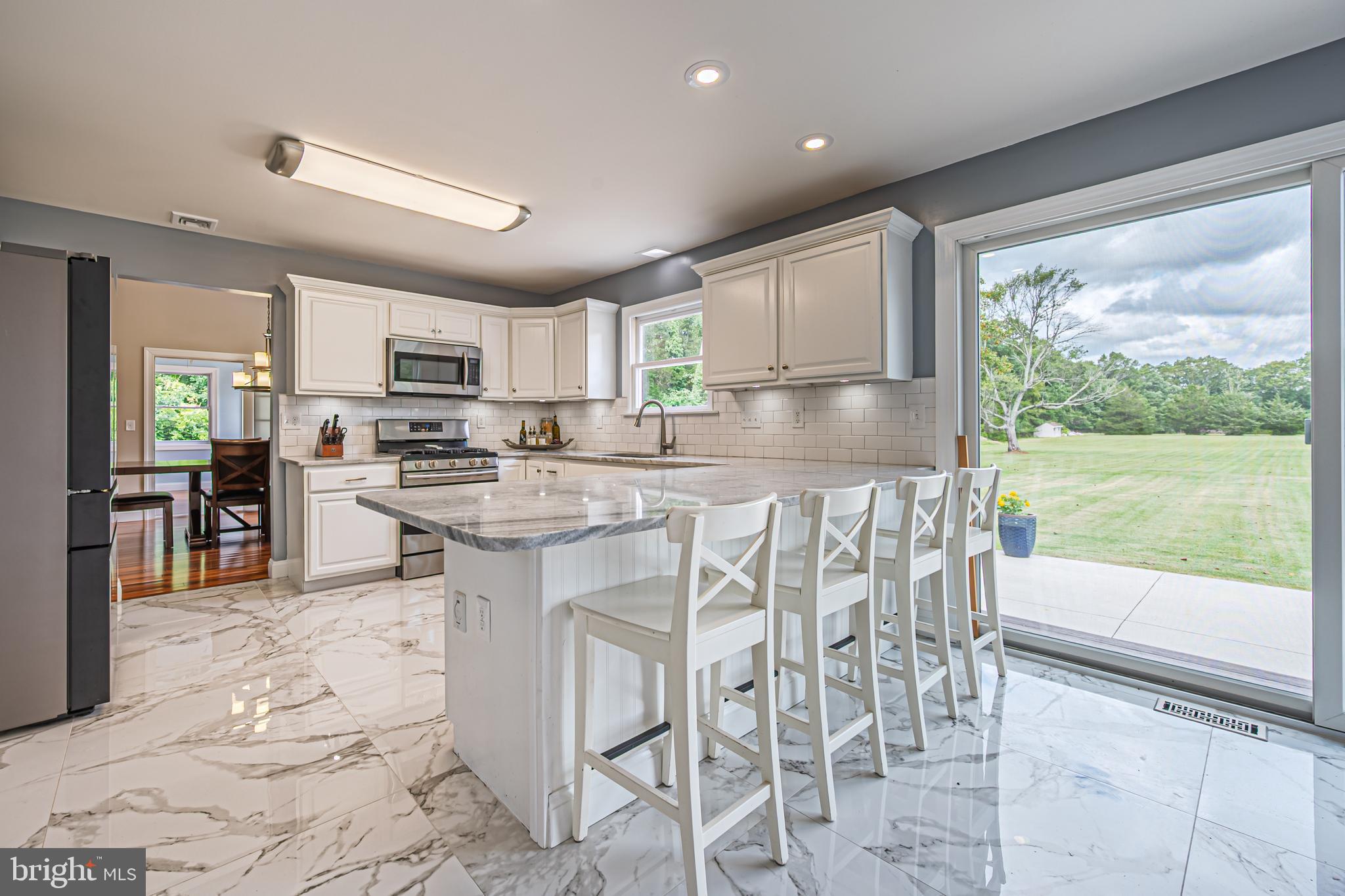 900 Elwood Road, Unit MULLICA Hammonton, NJ 08037 - Photo 15 of 56 a kitchen with stainless steel appliances granite countertop a stove top oven a sink a dining table and chairs