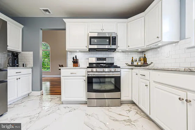 a view of a kitchen with kitchen island granite countertop lots of counter top space