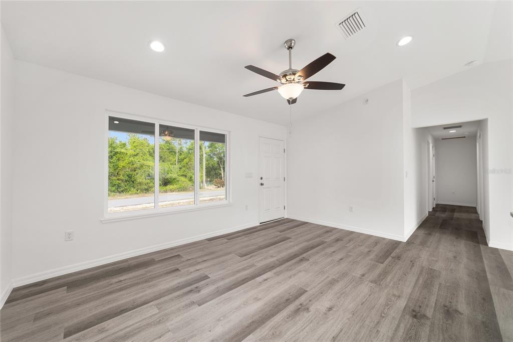 13078 Northeast 7th Loop Silver Springs, FL 34488 - Photo 11 of 56 a view of empty room with wooden floor and fan