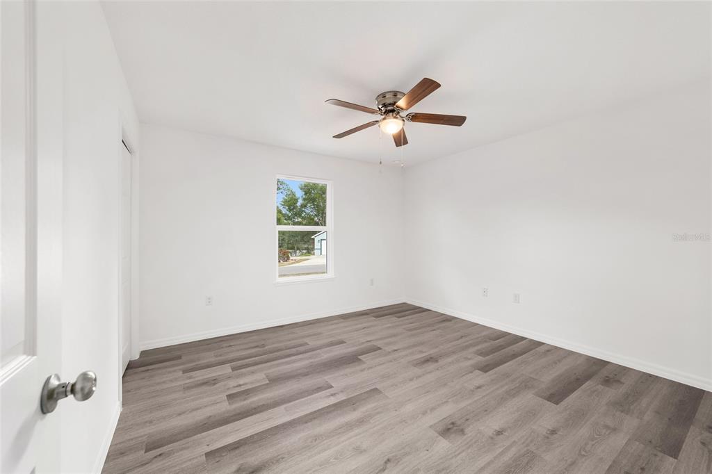 13078 Northeast 7th Loop Silver Springs, FL 34488 - Photo 32 of 56 a view of empty room with wooden floor and fan