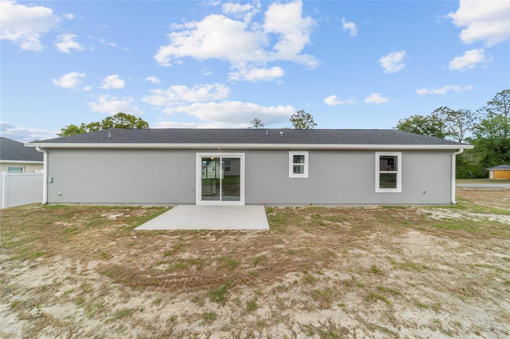 13078 Northeast 7th Loop Silver Springs, FL 34488 - Photo 39 of 56 a view of a house with a backyard and floor to ceiling windows