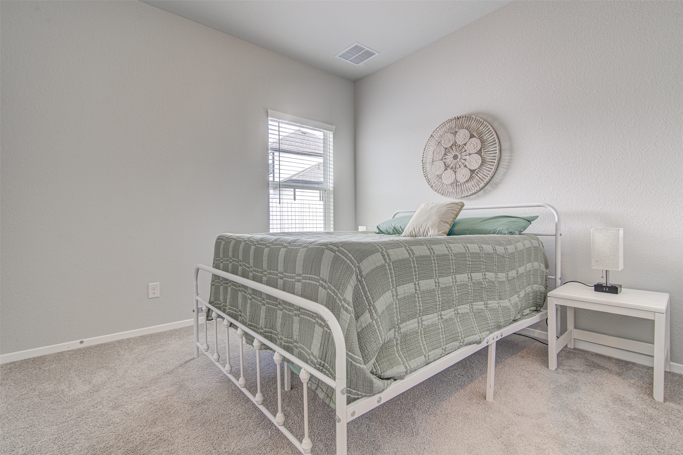 156 Tillage Road Elgin, TX 78621 - Photo 15 of 25 Well-lit and tranquil, this bedroom provides a peaceful retreat with its soft neutral palette.