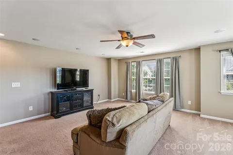 a spacious bedroom with a bed and a flat screen tv
