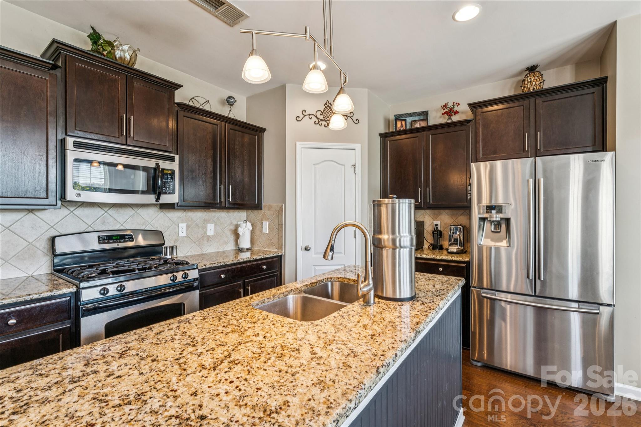 8211 Viewpoint Lane Cornelius, NC 28031 - Photo 10 of 28 a kitchen with stainless steel appliances granite countertop a refrigerator a stove top oven a sink dishwasher a refrigerator and cabinets with wooden floor