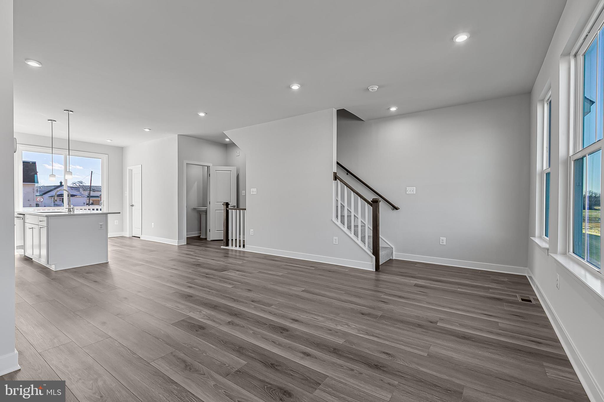 60 C Oasis Avenue Ranson, WV 25438 - Photo 21 of 38 a view of an empty room with wooden floor and a kitchen