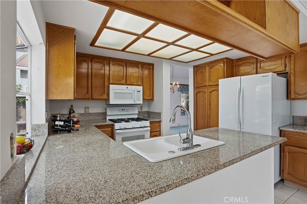 25497 Blackwood Road Murrieta, CA 92563 - Photo 14 of 44 a kitchen with stainless steel appliances granite countertop a sink a stove and a wooden cabinets